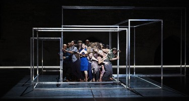 Group of people crowded into hollow metal box.