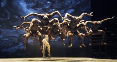 Group of dancers jump in unison.