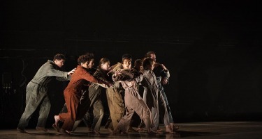 RUBBERBAND, Ever So Slightly. Group of dancers huddled on left side of stage.