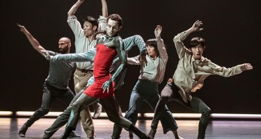 Group of dancers with arms raised.