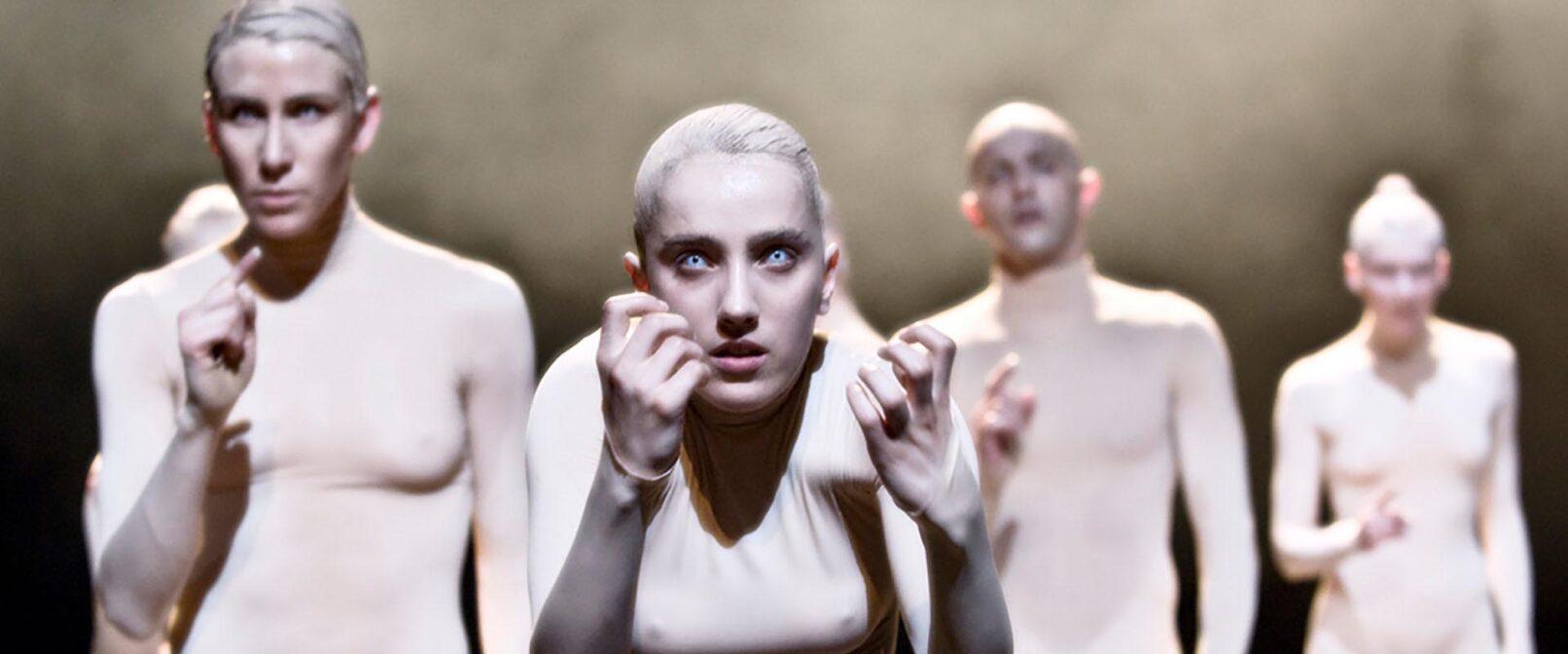 Carte Blanche. A group of pale figures in white full body leotards.