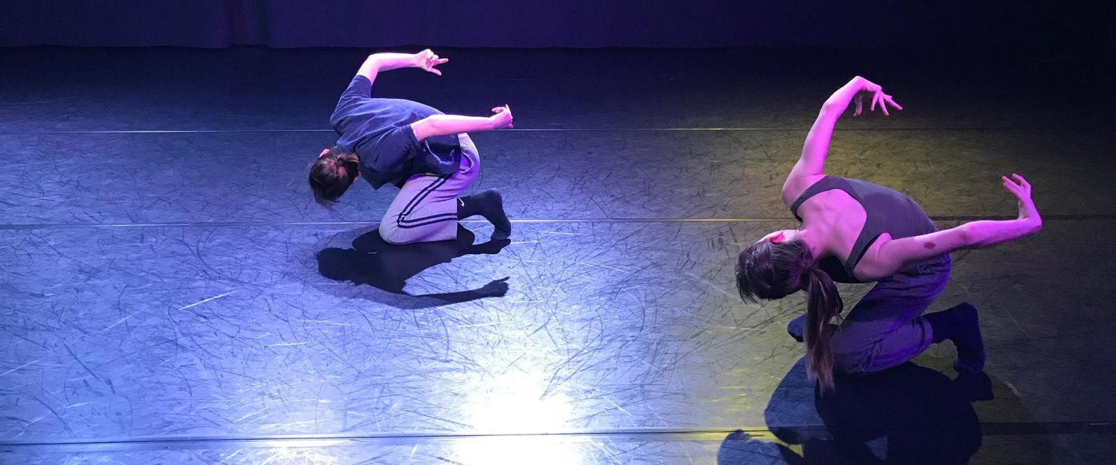 Oksana Hayduk and Alder Sherwood by Zahra Shahab. Two people crouched on one knee, bent forward with arms outstretched behind them.